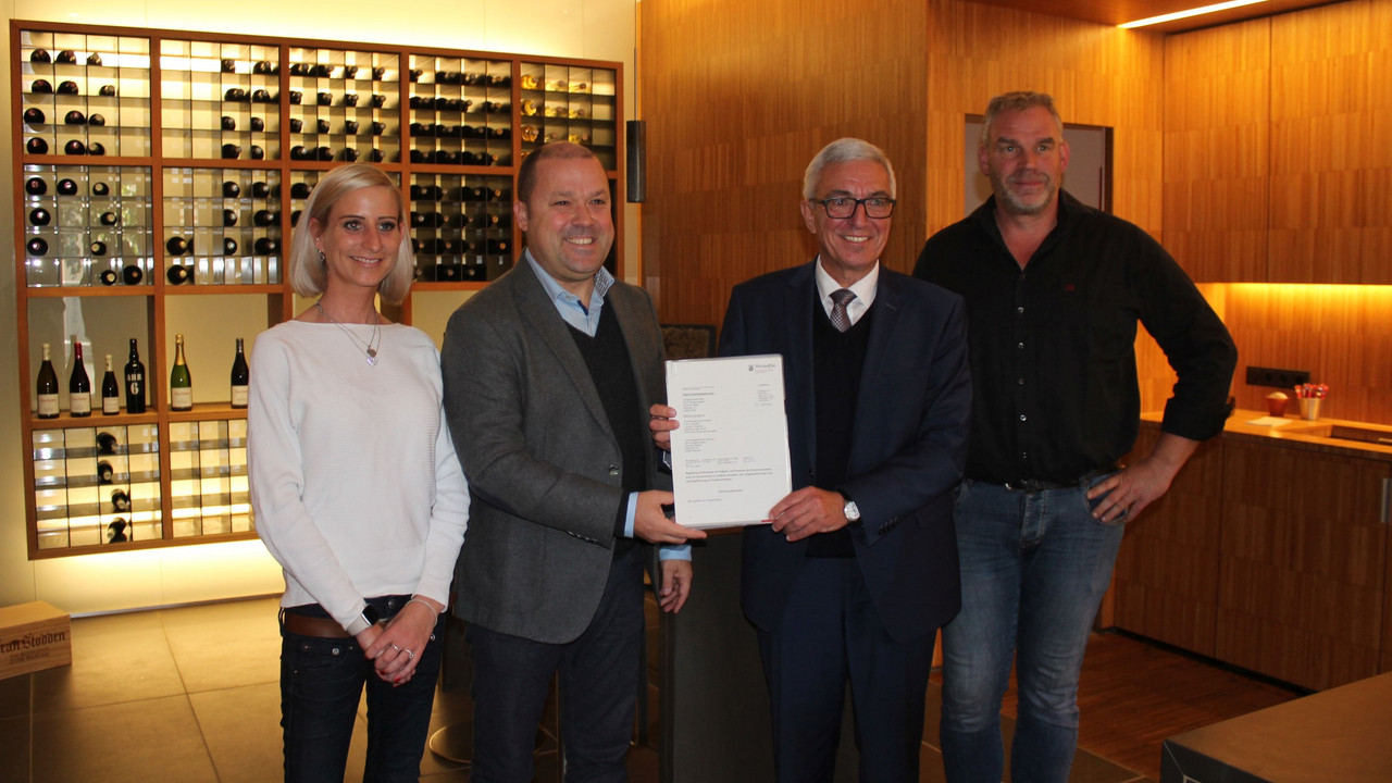 Ortsbürgermeister Benjamin Vrijdaghs (2.v.l.) und Innenminister Roger Lewentz (3.v.l.) bei der Übergabe des Förderbescheids im Rotweingut Jean Stodden.