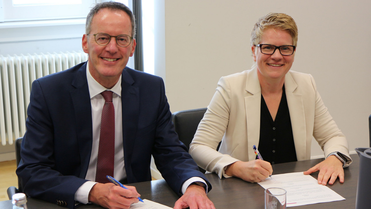 Innenminister Michael Ebling und die Vorsitzende des Hauptpersonalrates der Polizei, Sabrina Kunz, unterzeichnen die neue Dienstvereinbarung.