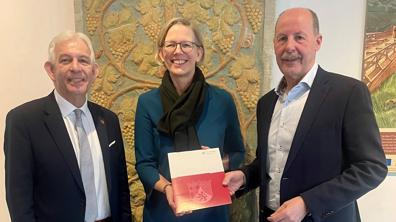 Staatssekretärin Simone Schneider (M.) bei der Bescheidübergabe mit dem Bürgermeister der Ortsgemeinde Neumagen-Dhron, Dieter Heintz (r.), und dem Bürgermeister der Verbandsgemeinde Bernkastel-Kues, Leo Wächter (l.).