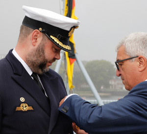 Innenminister Roger Lewentz steckt Fregattenkapitän Dr. Jan Jansen die Verdienstmedaille an