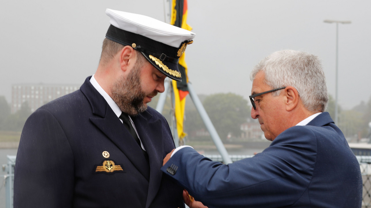 Innenminister Roger Lewentz steckt Fregattenkapitän Dr. Jan Jansen die Verdienstmedaille an
