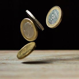 Vier Münzen fallen auf einen Tisch
