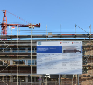Bauschild an der Baustelle in Trier. Hinter dem Gebäude steht ein Kran