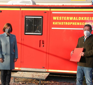 Staatssekretärin Nicole Steingaß (links) und Landrat Achim Schwickert (rechts) bei Bescheidübergabe. Beide mit Maske