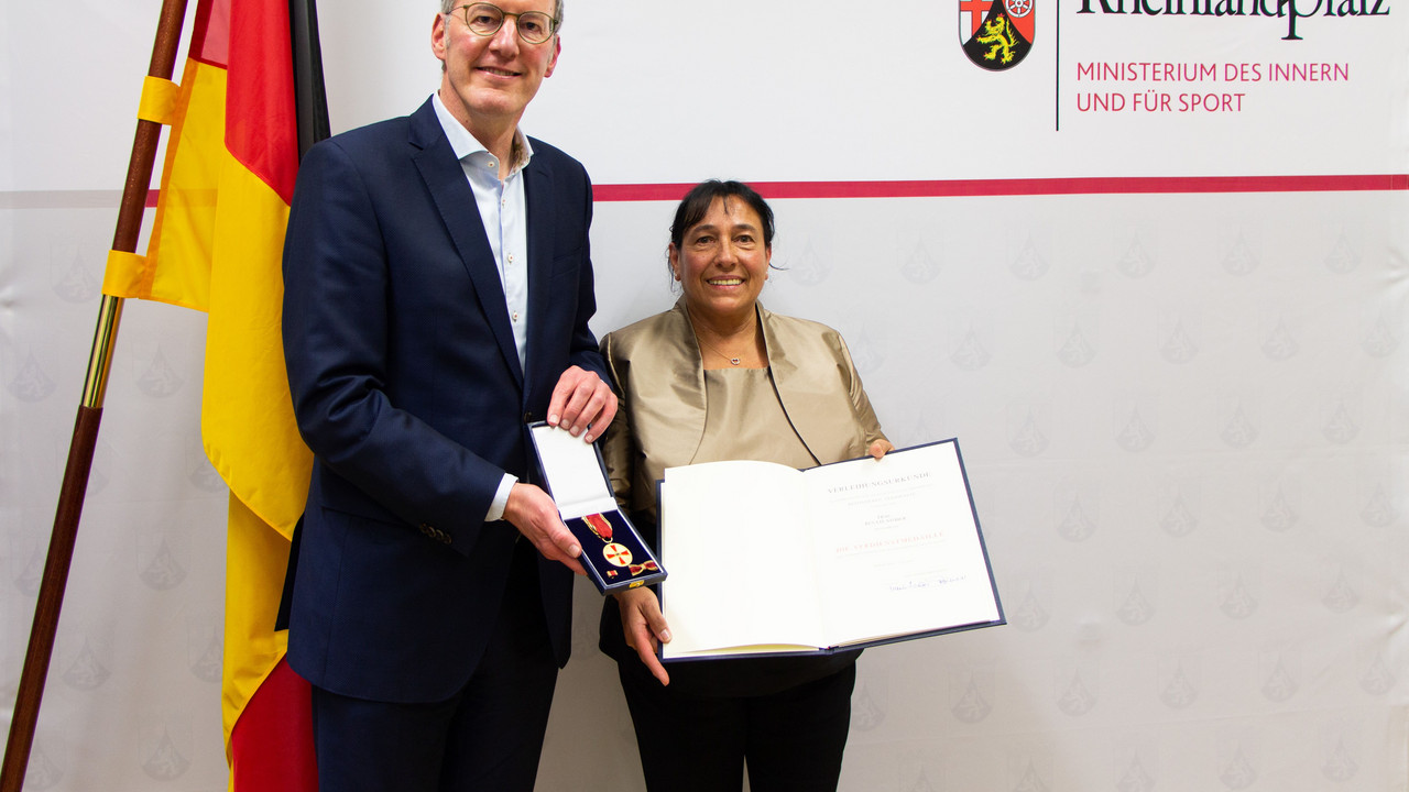 Innenminister Michael Ebling übergibt die Verdienstmedaille an Renate Stöber.