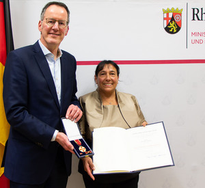 Innenminister Michael Ebling übergibt die Verdienstmedaille an Renate Stöber.