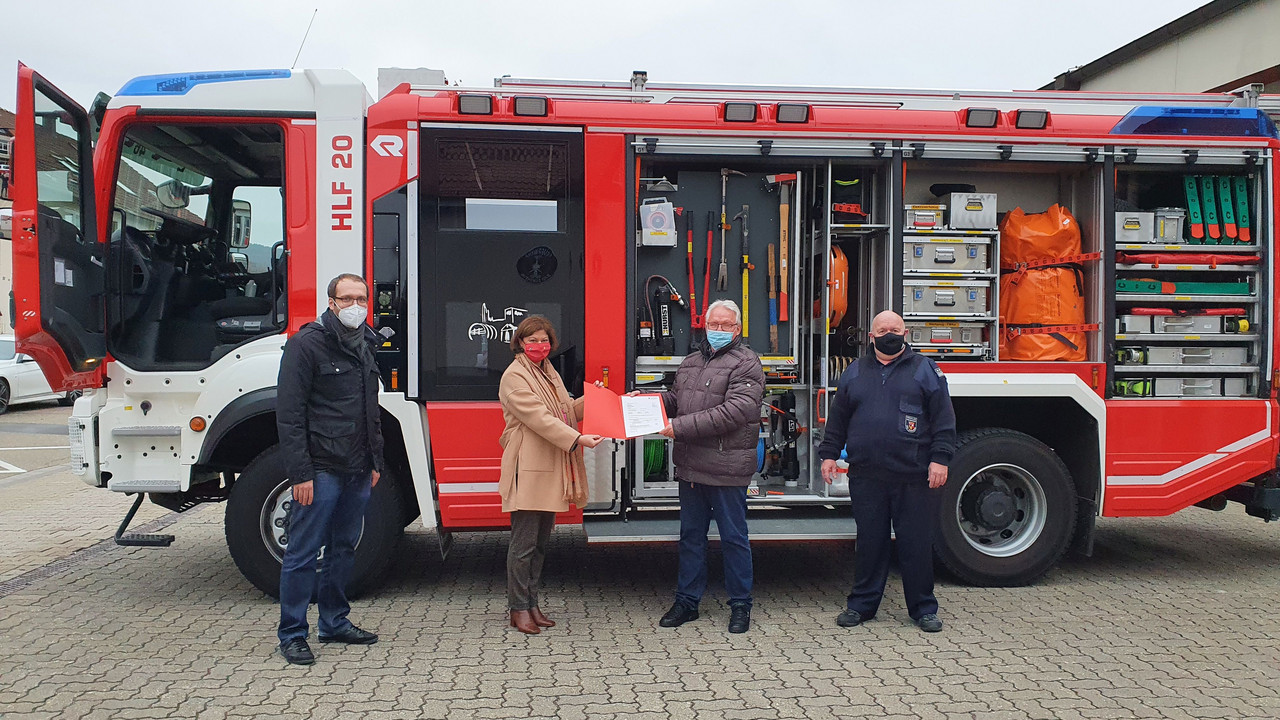 Übergabe Förderbescheid vor einem Feuerwehrauto