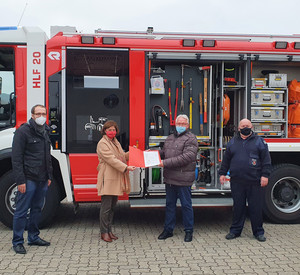 Übergabe Förderbescheid vor einem Feuerwehrauto