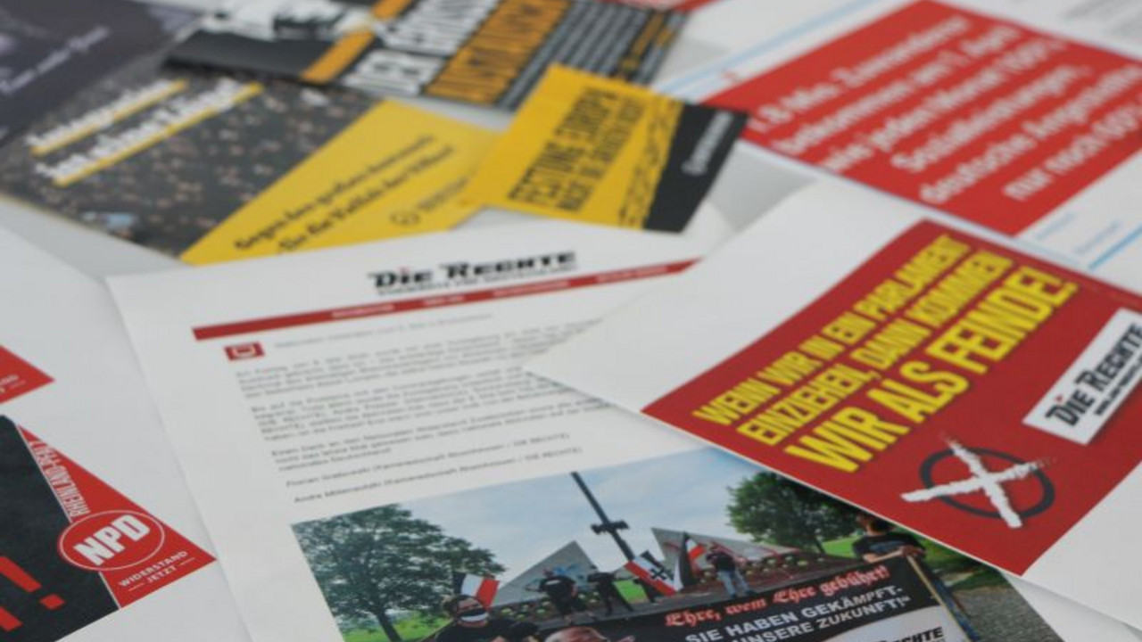 Auf einem Tisch liegen Ausdrucke von Artikeln, Werbung und sonstiger Publikationen extremistischer, verfassungsfeindlicher Gruppierungen