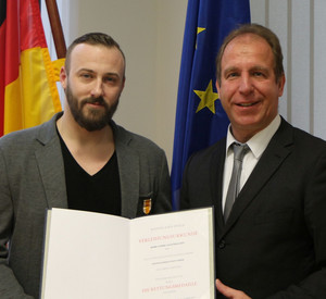 Staatssekretär Randolf Stich hat André Legenhausen mit der Rettungsmedaille ausgezeichnet.