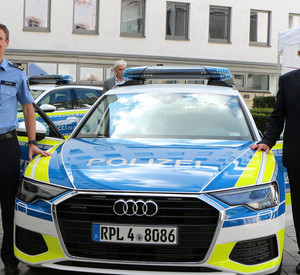 Innenminister Roger Lewentz (rechts im Bild) steht mit einem Polizeibeamten (links im Bild) neben einem Polizeiauto der Marke Audi A6 Avant
