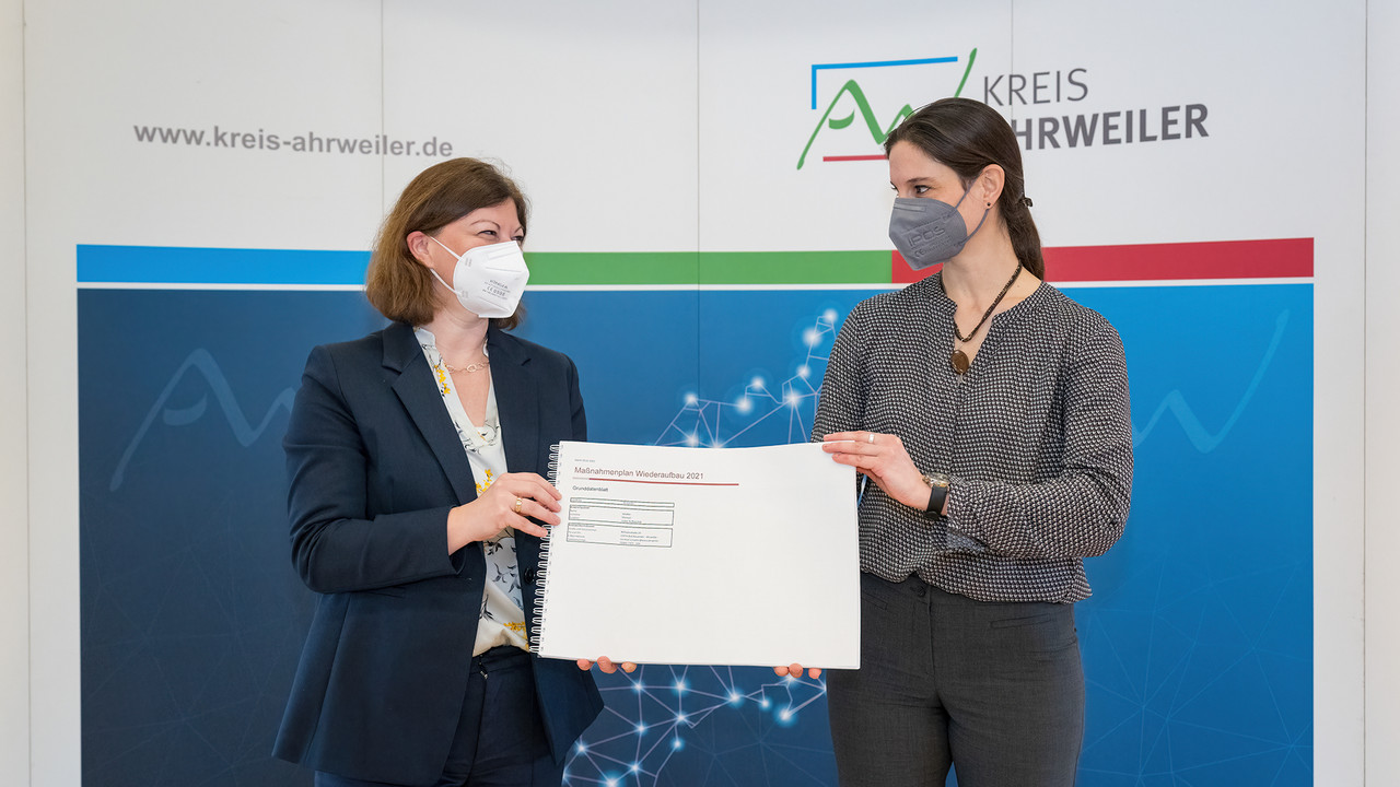 Wiederaufbaubeauftragte Nicole Steingaß nimmt den Maßnahmenplan des Landkreises Ahrweiler entgegen.