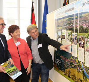 Die Bürgermeister der teilnehmenden Ortsgemeinden Duchroth und Oberhausen zeigen Innenminister Lewentz ihre Dorferneuerungsmaßnahmen.
