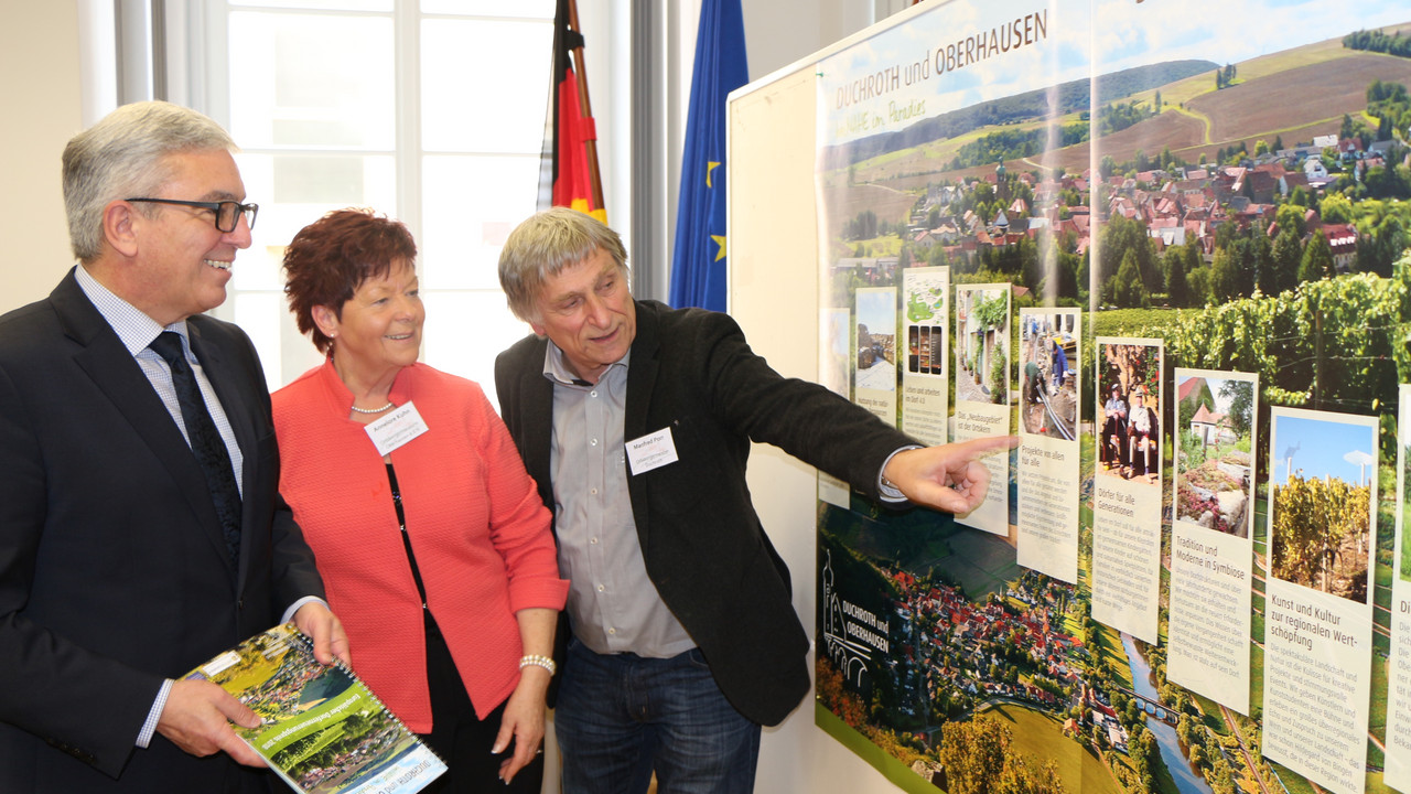 Die Bürgermeister der teilnehmenden Ortsgemeinden Duchroth und Oberhausen zeigen Innenminister Lewentz ihre Dorferneuerungsmaßnahmen.