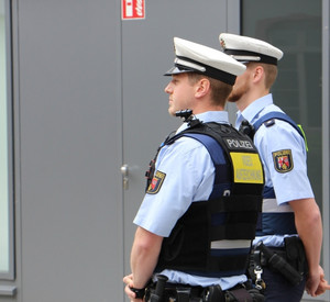 Bodycam - der offene Kameraeinsatz erzeugt eine deeskalierende Wirkung. Zwei Polizisten präsentieren die kleine Kamera, die auf der Schulter angebracht ist.