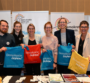 Staatssekretärin Simone Schneider (2.v.r.) mit Bildungsministerin Dr. Stefanie Hubig (3.v.l.) und Wirtschaftsstaatssekretärin Petra Dick-Walther (r.) am Stand des Demokratiezentrums RLP.