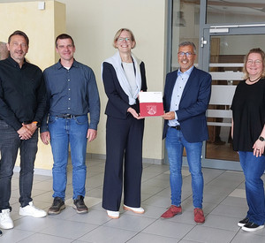 Staatssekretärin Simone Schneider (M.) überreicht dem Ortsbürgermeister von Schwegenheim, Andreas Weber (3. v. r.), einen Förderbescheid.