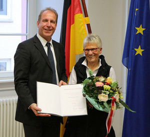 Staatssekretär Randolf Stich überreicht Dagmar Lehmann die Ehrennadel