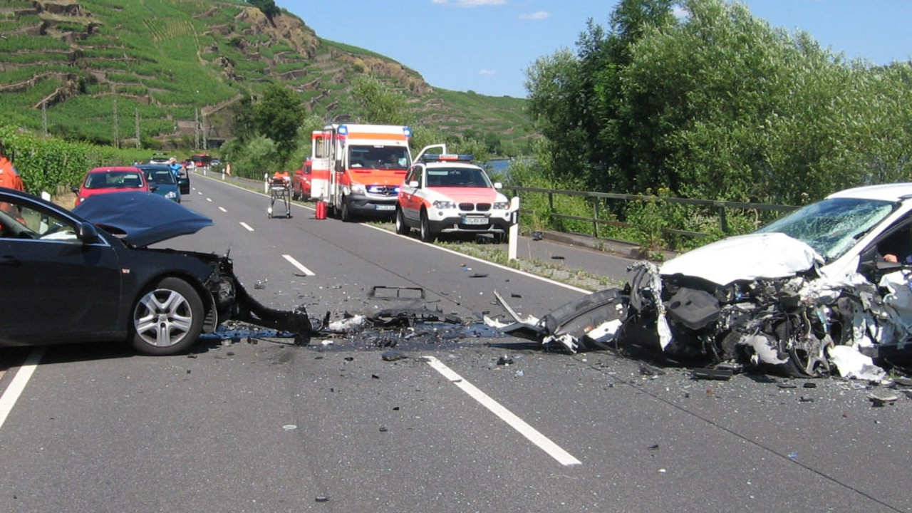 Verkehrsunfall mit zwei PKWs. Im Hintergrund stehen Rettungswagen bereit.