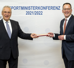 Der rheinland-pfälzische Innen- und Sportminister Michael Ebling gibt den Staffelstab der Sportministerkonferenz an Bayerns Innen- und Sportminister Joachim Herrmann ab.