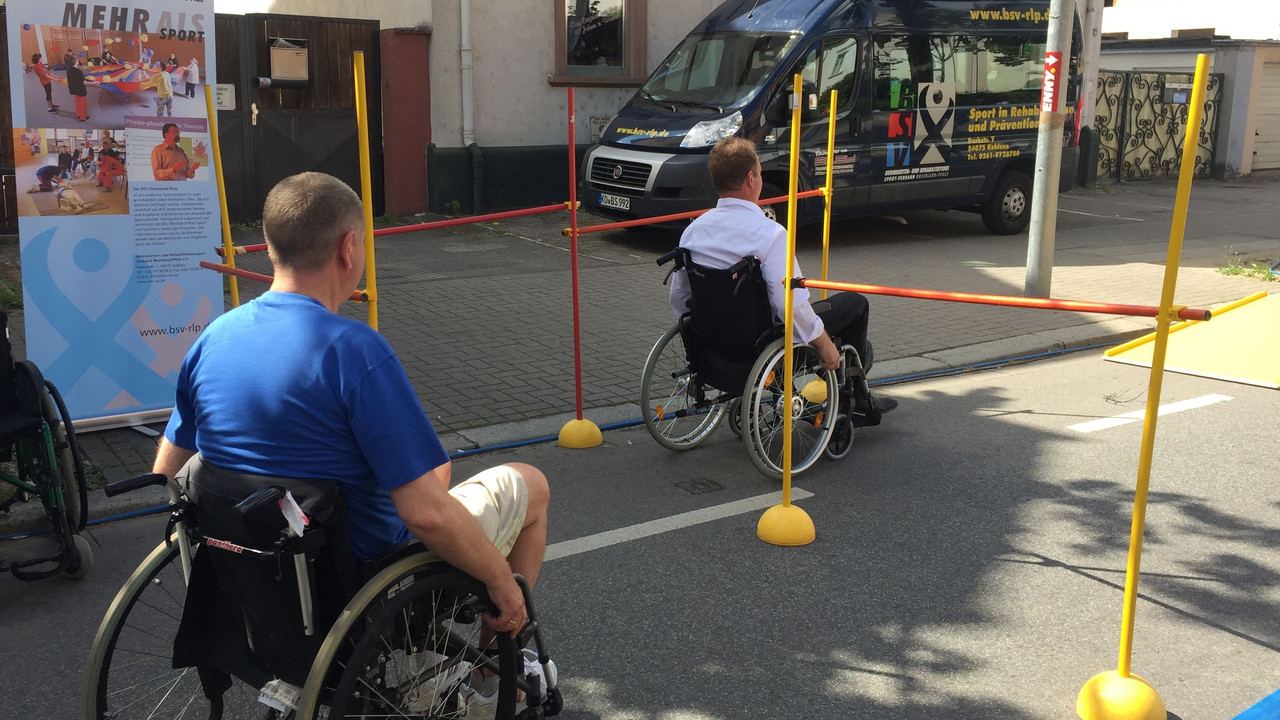 Staatssekretär Stich fährt in einem Rollstuhl einen Parcour.