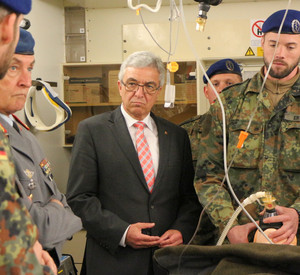 Soldaten demonstrieren an einem Dummy die notärtzliche Versorgung. Innenminister Roger Lewentz und General Tempel schauen zu.