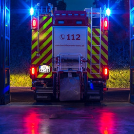 Beleuchtetes Feuerwehreinsatzfahrzeug bei Nacht