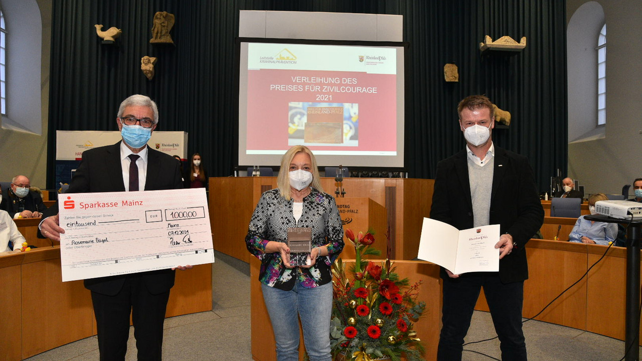 Innenminister Roger Lewentz mit Preisträgerin Rosemarie Bügel und Laudator Olaf Holzbach