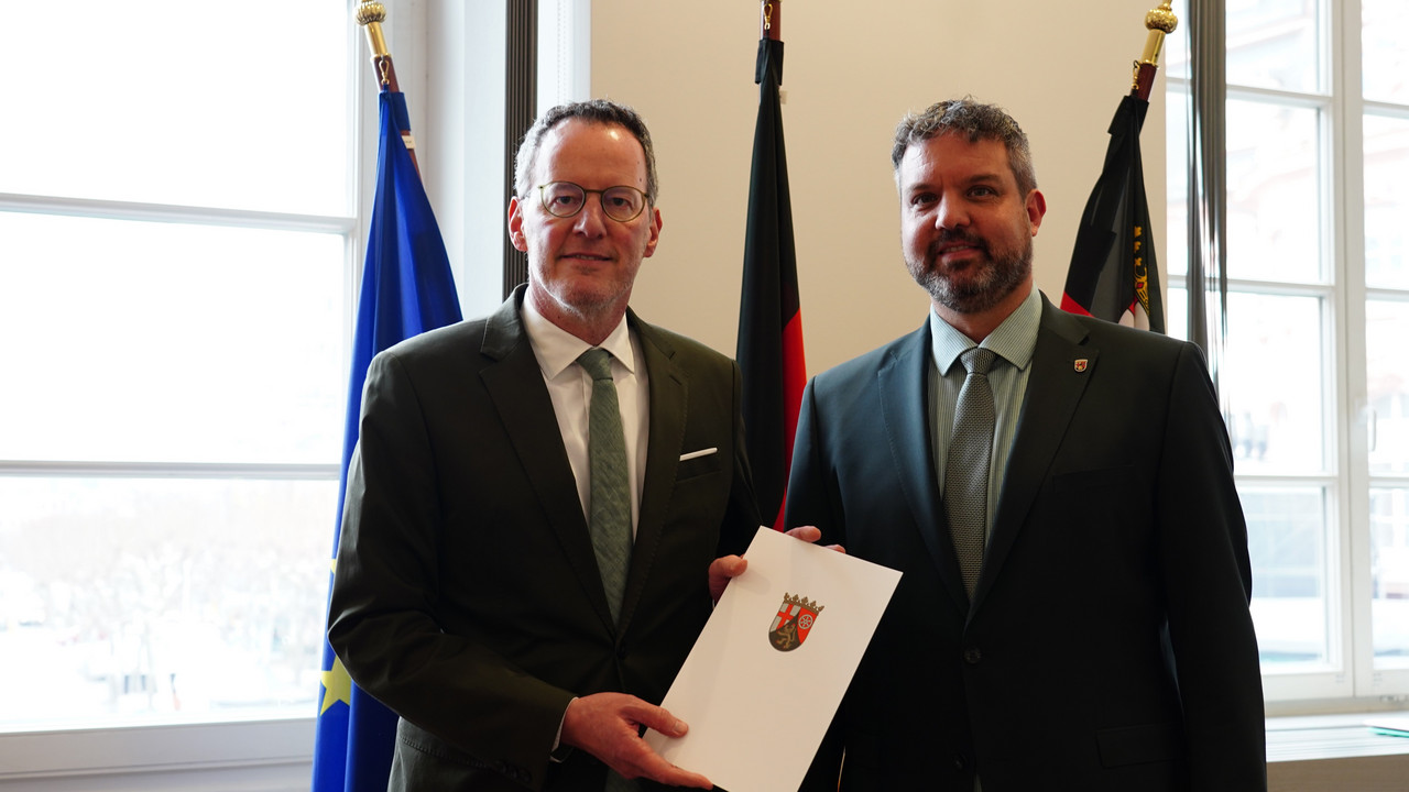 Innenminister Michael Ebling (l.) überreicht Marco Ludwig (r.) die Ernennungsurkunde zum Präsidenten des Statistischen Landesamts.