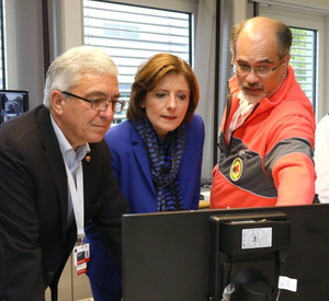 Innenminister Lewentz udn Ministerpräsidentin Malu Dreyer stehen vor einem Computer und blicken auf einen Bildschirm. Ein Mitarbeiter des Rettungsdienstes erläutert, was auf dem Bildschirm zu sehen ist.