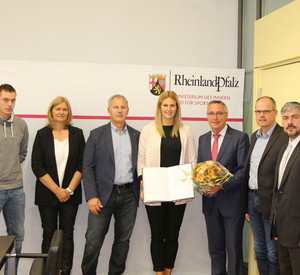 Staatssekretär Günter Kern überreicht Christin Hussong die Sportplakette