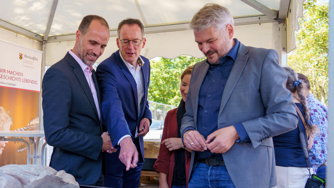 Innenminister Ebling und Wissenschaftsminister Hoch begutachten einen Teil der archäologischen Funde auf dem Baufeld.