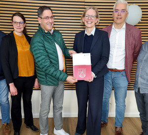 Staatssekretärin Simone Schneider übergibt den Förderbescheid an Altenahrs Ortsbürgermeister Neofitos Arathymos. 