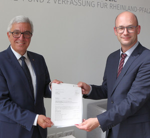 Innenminister Roger Lewentz übergibt den Förderbescheid an Ortsbürgermeister Carsten Göller.