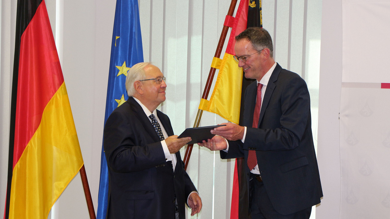 Innenminister Michael Ebling überreicht Ortwin Neuschwander das Verdienstkreuz am Bande.
