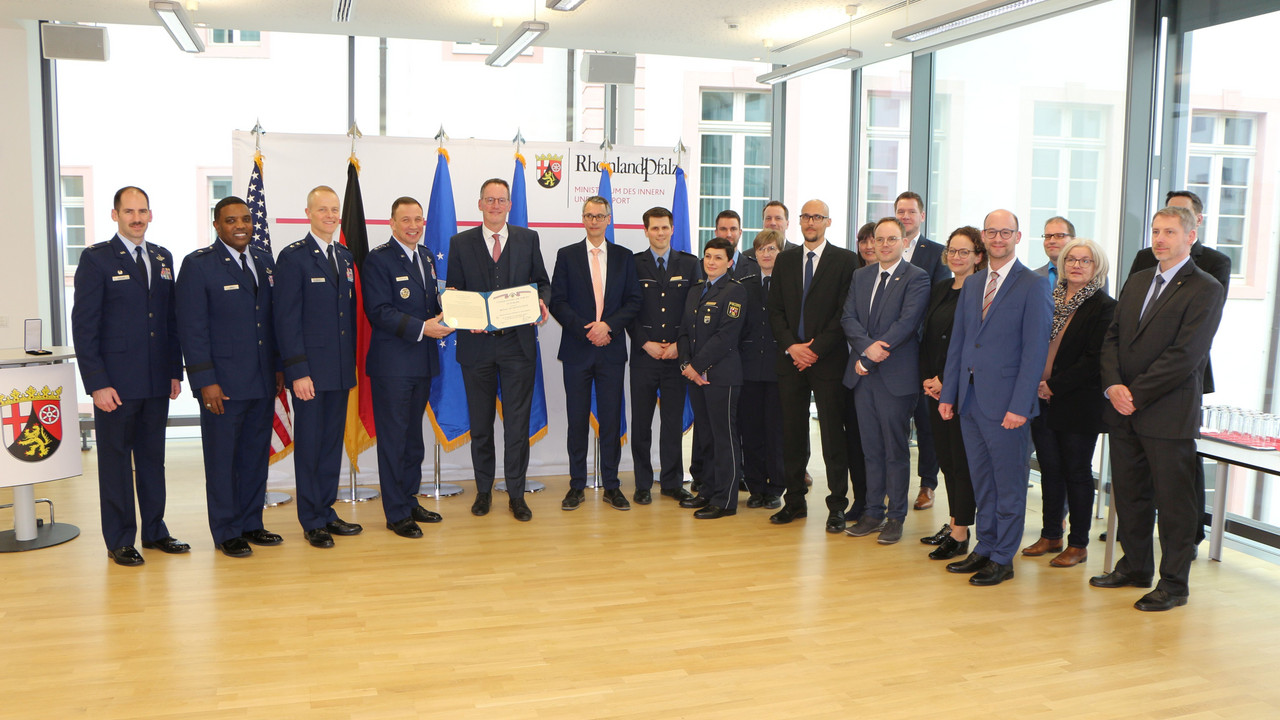 Innenminister Michael Ebling, Mitarbeiterinnen und Mitarbeiter des Ministeriums und Vertreter der US-Streitkräfte bei der Verleihung der Ehrenmedaille.