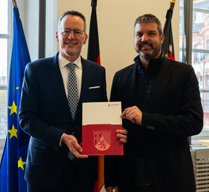 Innenminister Michael Ebling überreicht dem Bürgermeister von Nastätten, Marco Ludwig, die Förderbescheide.