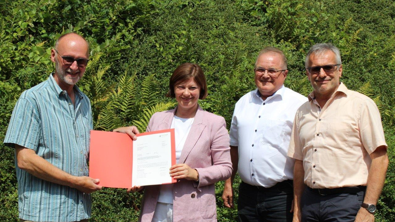 Staatssekretärin Nicole Steingaß mit Ortsbürgermeister von Rumbach, Ralf Weber (links), sowie dem dritten Kreisbeigeordneten Josef Bauer und dem Verbandsbürgermeister der VG Dahner Felsenland, Michael Zwick bei der Bescheidübergabe