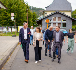 Minister Ebling bei einem Rundgang durch das Bahnhofsumfeld von Ahrbrück, welches mit Unterstützung der Kommunal-Koordinatoren neu gestaltet werden soll.