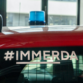 Die Rückseite eines Feuerwehreinsatzfahrzeuges. Auf der Fensterscheibe steht in weißer Schrift #immerda.