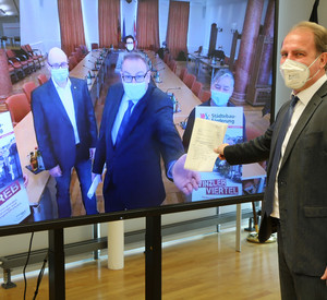 Staatssekretär Randolf Stich bei der virtuellen Bescheidübergabe an Bürgermeister Markus Zwick