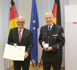 Innenminister Roger Lewentz verleiht Brand- und Katastrophenschutzinspekteur a.D. Axel Simonis das Goldene Feuerwehr-Ehrenzeichen als Steckkreuz