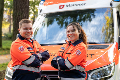 Personal im Rettungsdienst vor Einsatzfahrzeug Personal im Rettungsdienst vor Einsatzfahrzeug