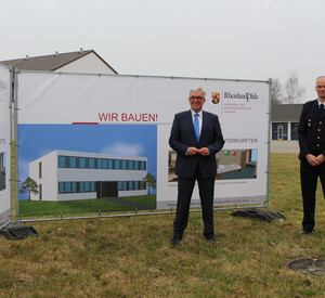 Innenminister Roger Lewentz und der stellvertretende Schulleiter, Oberbrandrat Thomas Kreuz, mit den Planungen zum Erweiterungsbau an der LFKA
