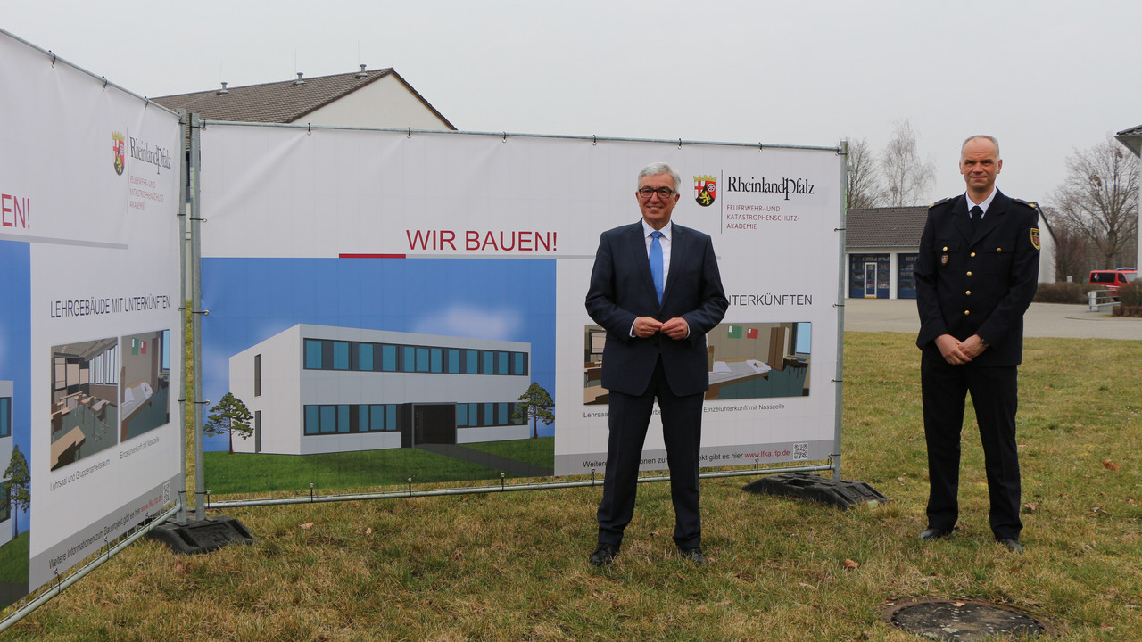 Innenminister Roger Lewentz und der stellvertretende Schulleiter, Oberbrandrat Thomas Kreuz, mit den Planungen zum Erweiterungsbau an der LFKA
