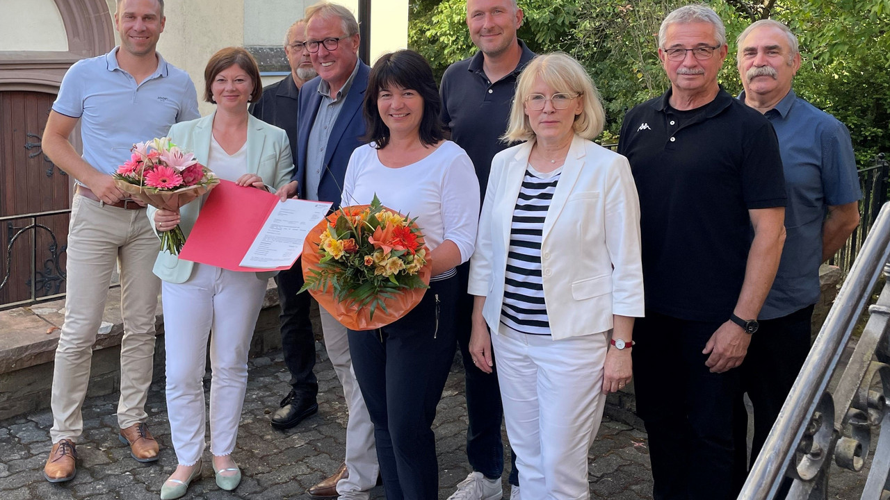 Staatssekretärin Nicole Steingaß (2.v.r.) und Ortsbürgermeister Manfred Klasen (4.v.r.) bei der Übergabe des Förderbescheids in Lasel. 