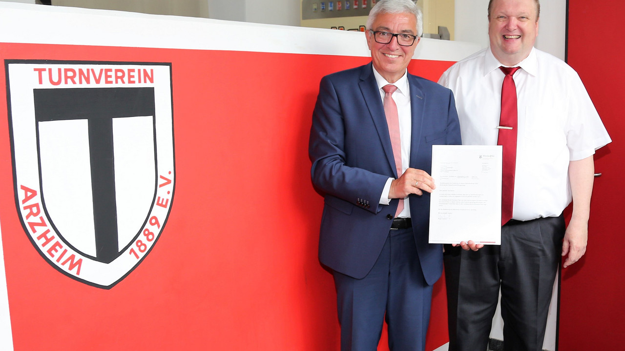Sportminister Roger Lewentz bei der Übergabe des Schreibens an den 2. Vorsitzenden des TV Arzheim, Uwe Münch.